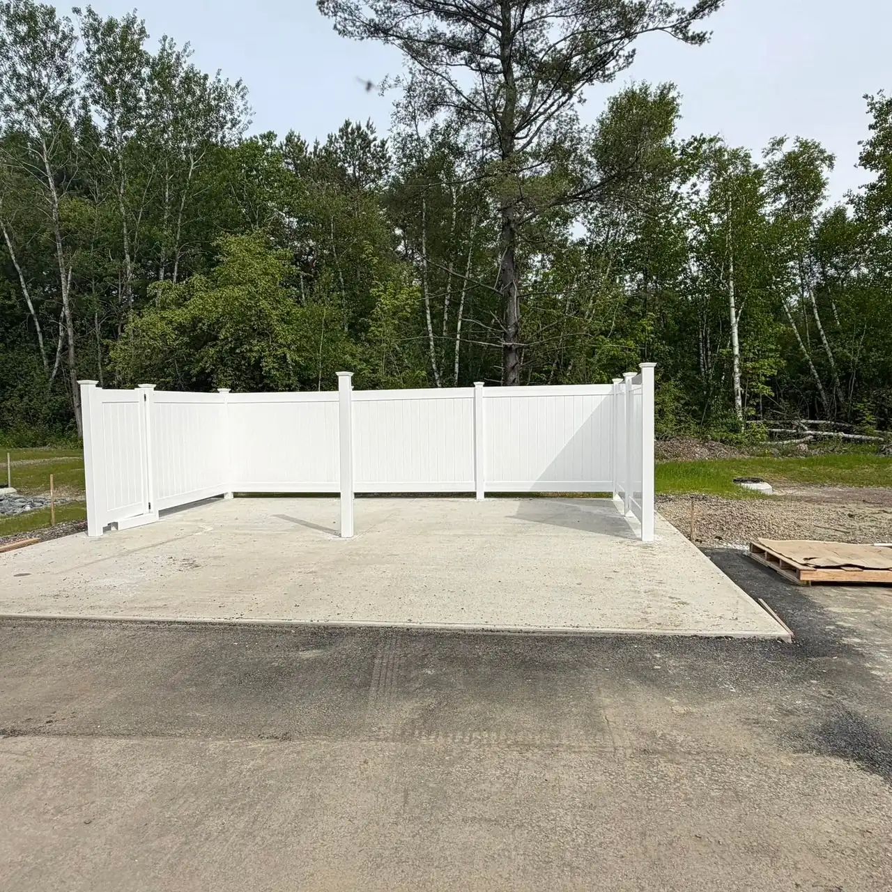 White vinyl privacy enclosure on a concrete pad