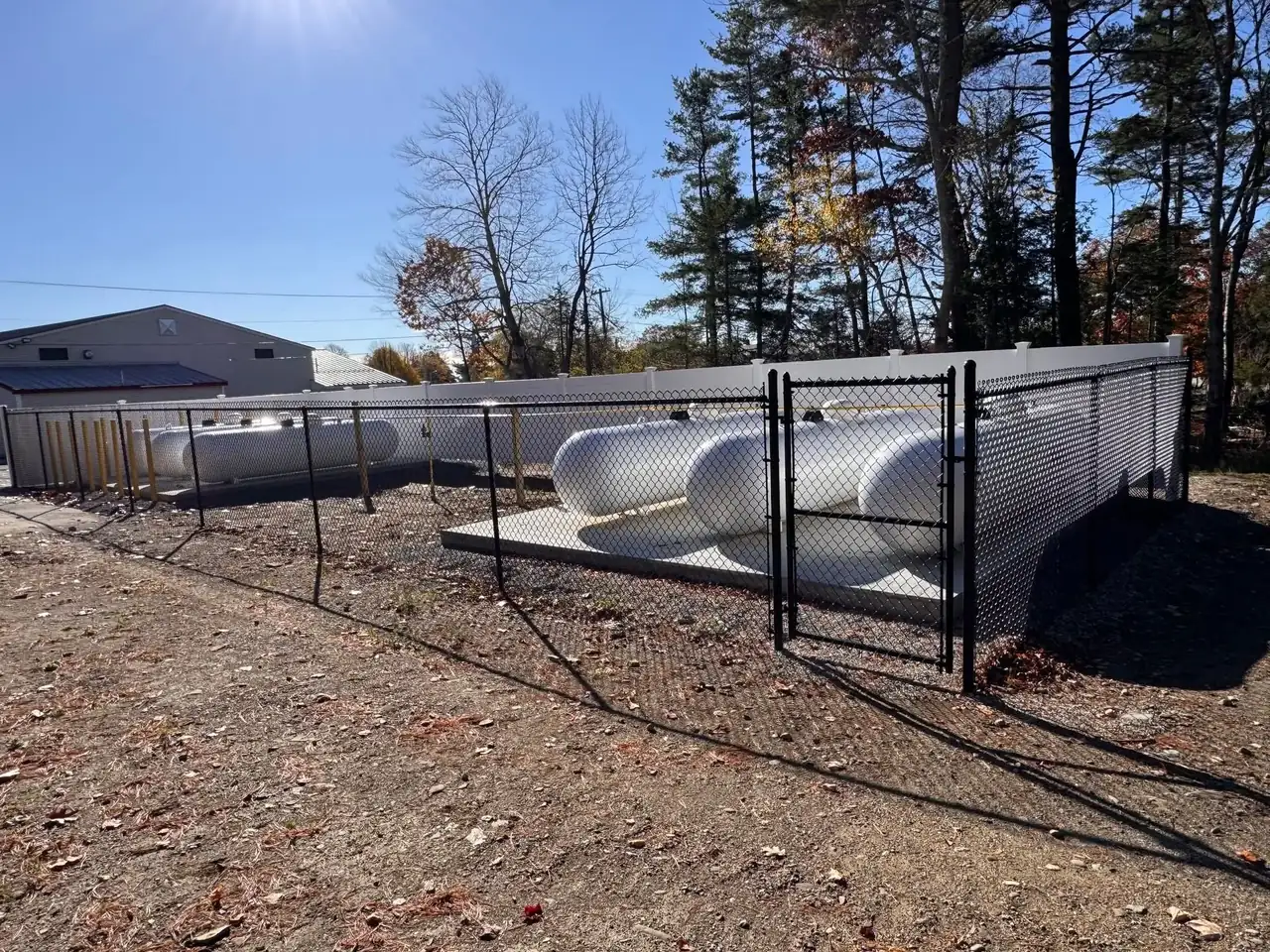 Black chain link enclosure around utility equipment