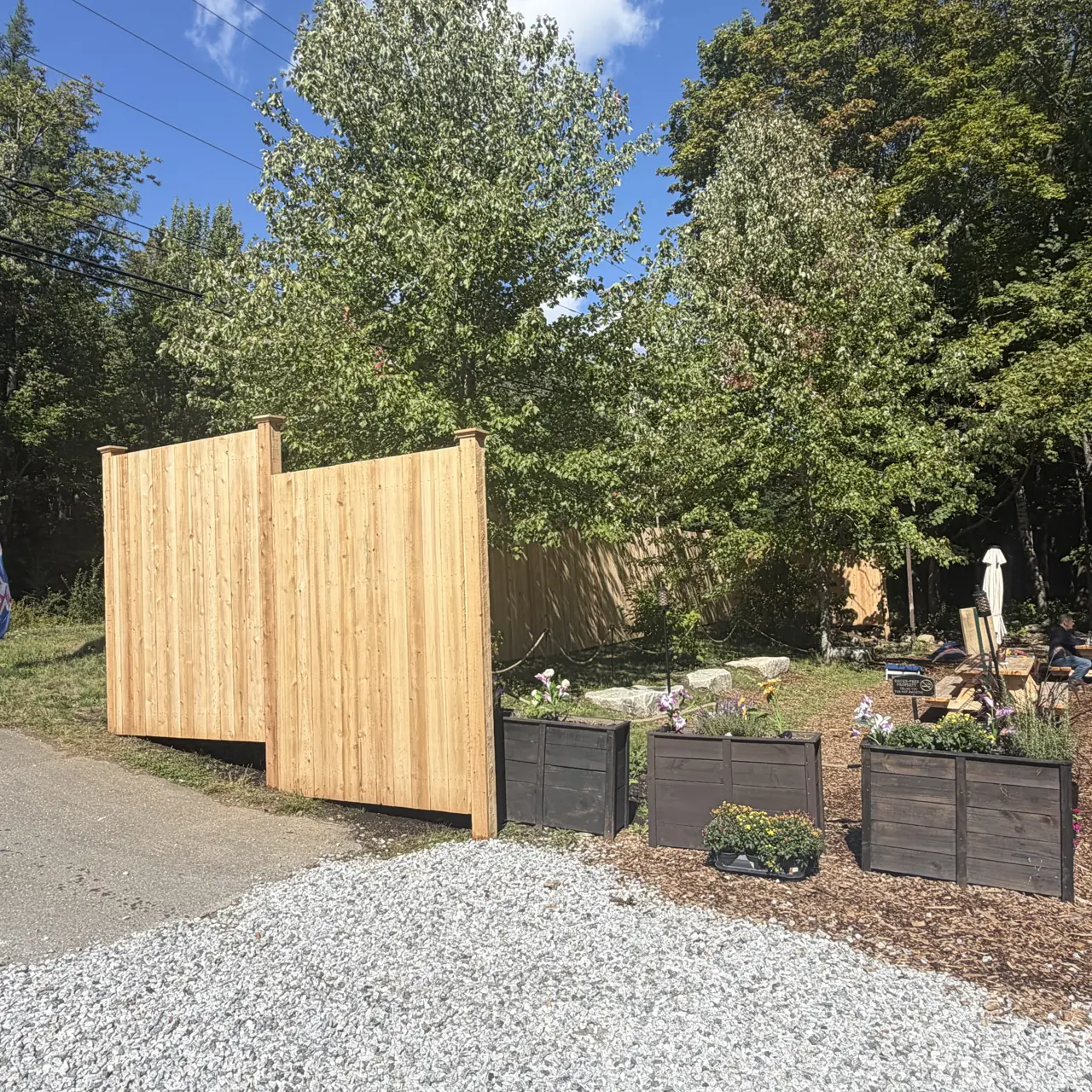 Wood privacy screening beside raised garden beds
