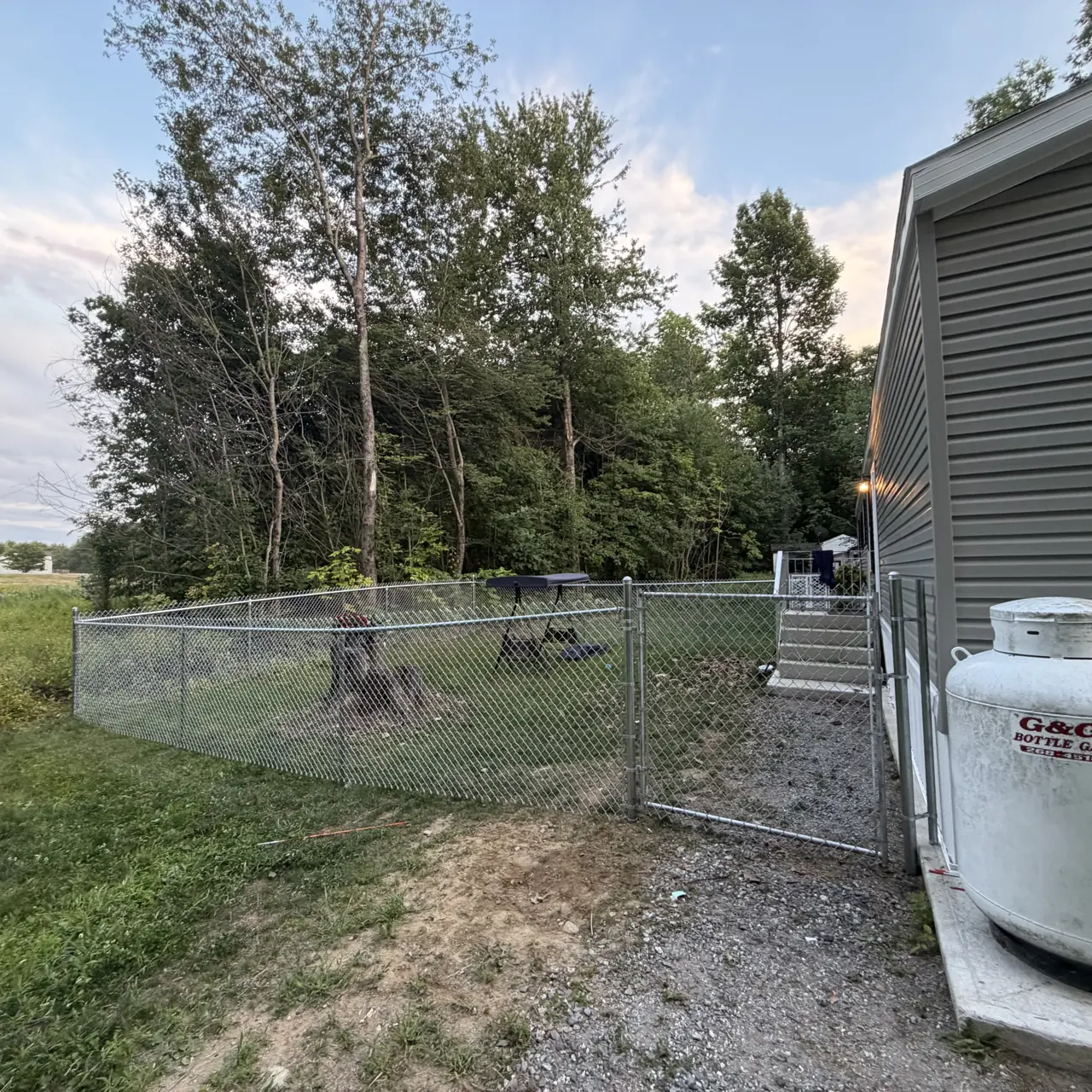 Chain link yard enclosure beside a home